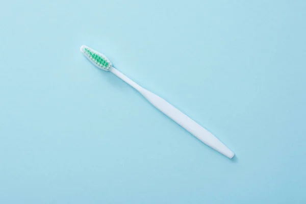 Vue du dessus de la brosse à dents blanche sur fond bleu — Photo de stock