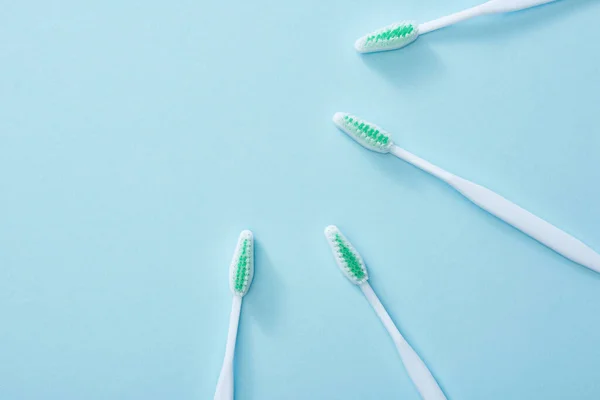 Vue du dessus des brosses à dents blanches sur fond bleu — Photo de stock