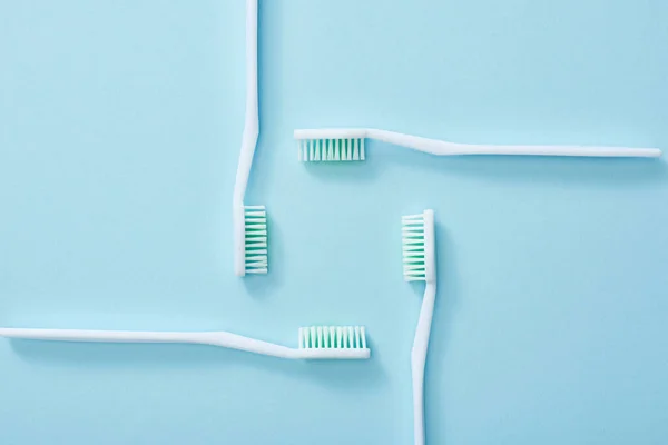 Acostado plano con cepillos de dientes establecidos sobre fondo azul - foto de stock