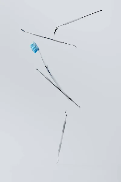 Зубні інструменти та зубна щітка, що вирівнюються на сірому фоні — стокове фото