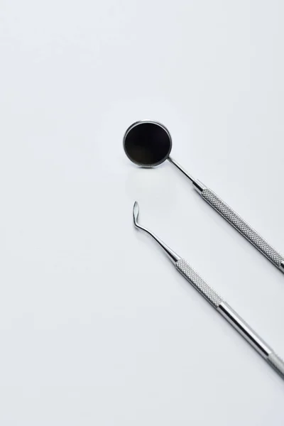 Vue grand angle du miroir dentaire et du sculpteur dentaire pour l'examen des dents sur fond gris — Stock Photo