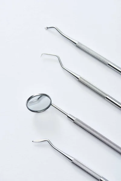 Visão de alto ângulo de instrumentos de exame odontológico profissional em fundo cinza — Fotografia de Stock