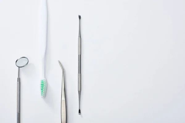 Top view of dental instruments and toothbrush on grey background — Stock Photo