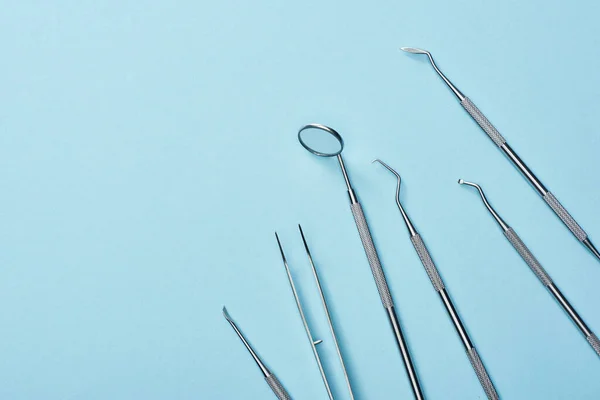 High angle view of metal dental equipment on blue background — Stock Photo