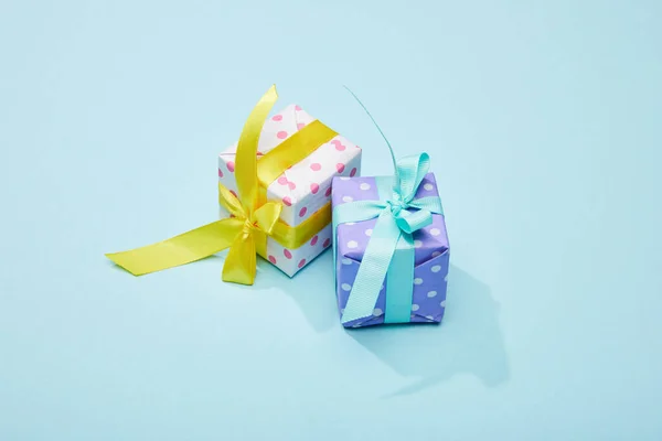 Gepunktete festliche bunte Geschenkboxen auf blauem Hintergrund — Stockfoto