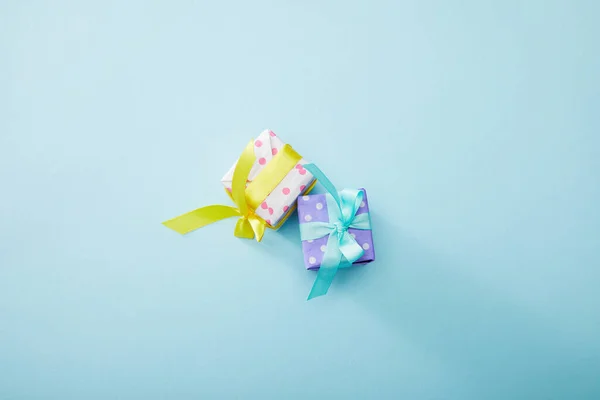Vue de dessus des boîtes-cadeaux colorées pointillées sur fond bleu — Photo de stock