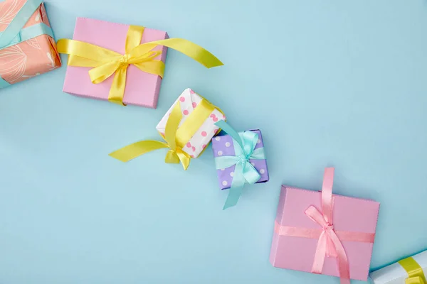 Vue du dessus des boîtes-cadeaux colorées festives sur fond bleu — Photo de stock