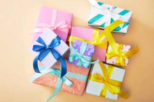 Vista superior de las cajas de regalo de colores festivos sobre fondo beige - foto de stock