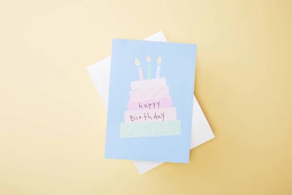 Vista superior de la tarjeta de felicitación festiva feliz cumpleaños sobre fondo beige - foto de stock
