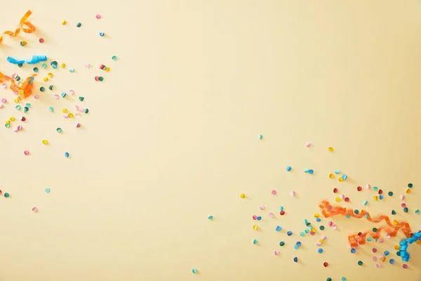 Top view of festive colorful confetti on beige background — Stock Photo