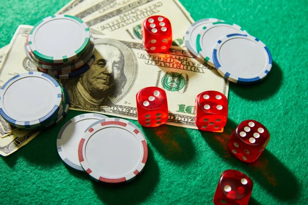 High angle view of dollar banknotes, dice and casino chips on green — Stock Photo