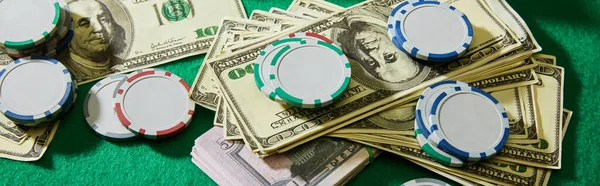 High angle view of dollar banknotes and casino chips on green background, panoramic shot — Stock Photo