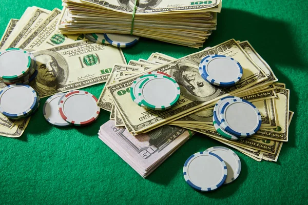 High angle view of dollar banknotes and casino chips on green background — Stock Photo