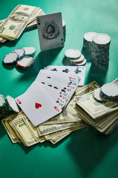Hohe Blickwinkel auf Spielkarten, Dollarnoten und Casino-Jetons auf Grün — Stockfoto