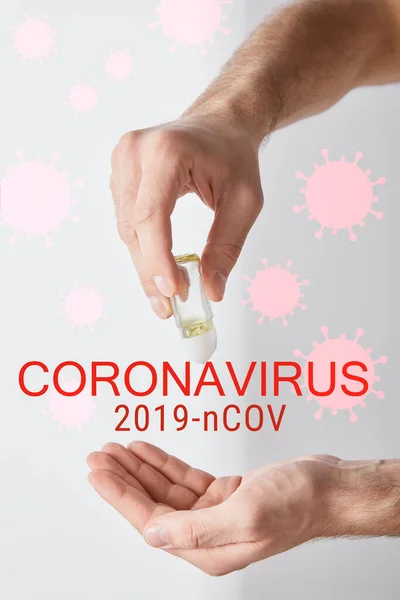 Cropped view of adult man using hand sanitizer on white background, coronavirus illustration — Stock Photo