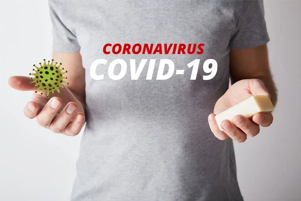 Vista parziale dell'uomo che tiene il sapone su sfondo grigio, coronavirus illustrazione — Foto stock