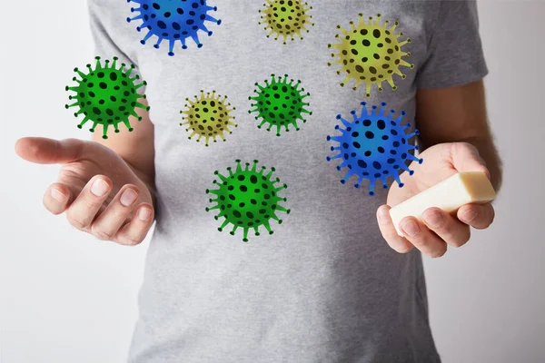 Partial view of man holding soap on grey background background, bacteria illustration — Stock Photo