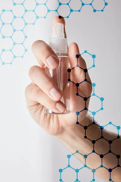 Ausgeschnittene Ansicht eines Mannes mit Händedesinfektionsmittel in Sprühflasche auf grauem Hintergrund, Darstellung der Molekülstruktur — Stockfoto