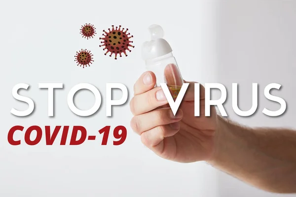 Vista ritagliata di uomo che tiene mano igienizzante su sfondo grigio, fermare l'illustrazione del virus — Foto stock