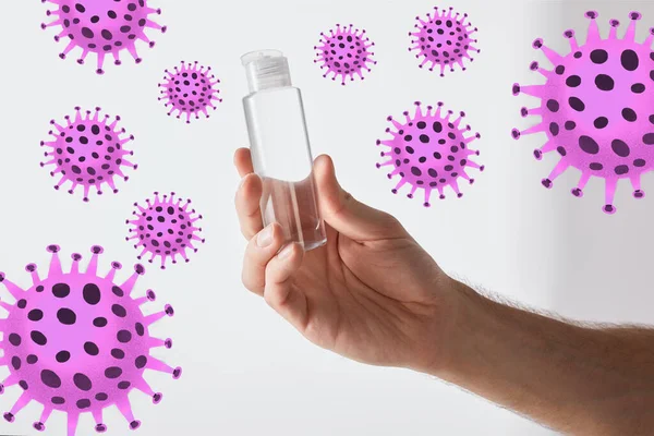 Cropped view of man holding hand sanitizer on grey background, bacteria illustration — Stock Photo