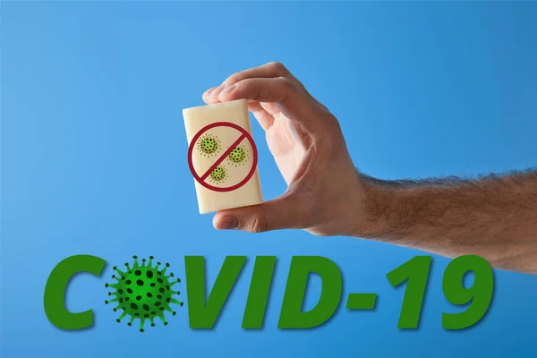 Vista ritagliata di uomo in possesso di sapone isolato su blu, covid-19 illustrazione — Foto stock