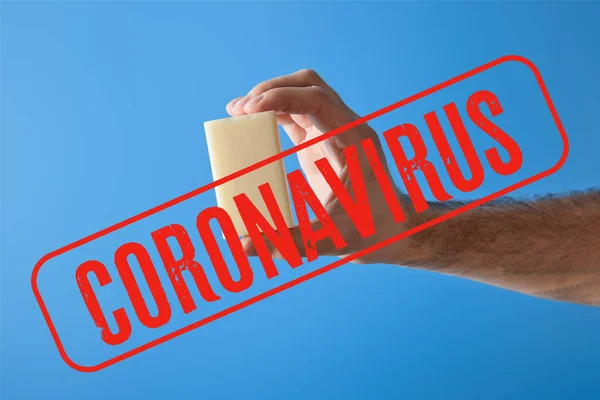 Vista ritagliata di uomo in possesso di sapone isolato su blu, coronavirus illustrazione — Foto stock