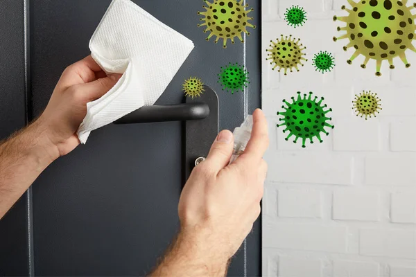 Partial view of man disinfecting metal door handle with antiseptic and napkin, bacteria illustration — Stock Photo