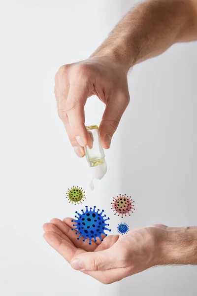 Vue recadrée de l'homme adulte en utilisant un désinfectant pour les mains sur fond blanc, illustration de bactéries — Photo de stock