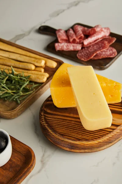 Vista de alto ângulo de placas com queijo e ingredientes antipasto no fundo branco — Fotografia de Stock