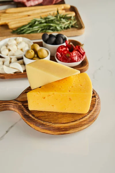 Foco seletivo de placas com queijo e ingredientes antipasto em branco — Fotografia de Stock