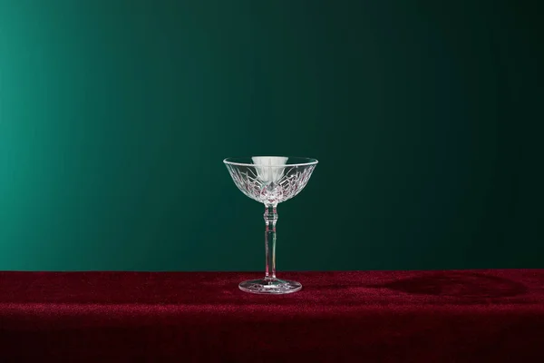 Cocktail glass on red velour surface isolated on green — Stock Photo