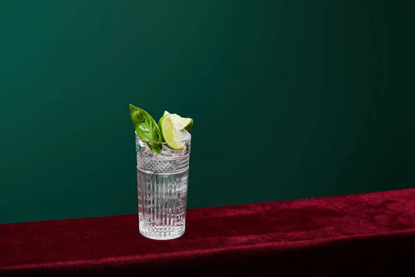 Vista ad alto angolo del mojito con ghiaccio, menta e calce in vetro collins isolato su verde — Foto stock