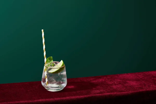 Hochwinkelblick auf altmodisches Glas mit goldenem Rand mit Mojito und gestreiftem Trinkhalm isoliert auf Grün — Stockfoto