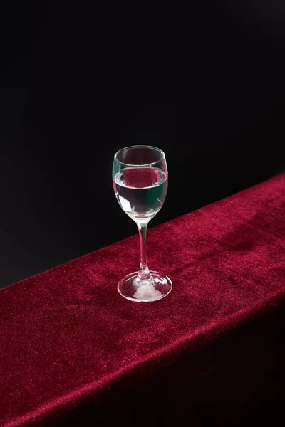 High angle view of shot glass with pure transparent liquid isolated on black — Stock Photo