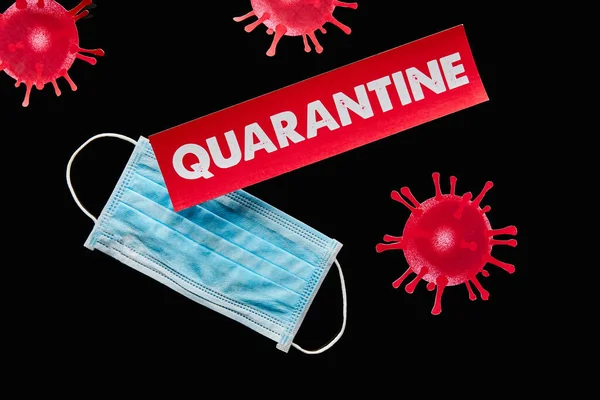 Top view of drawn virus near paper with red quarantine lettering and blue medical mask isolated on black — Stock Photo