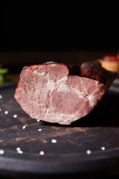 Close up view of tasty ham on board with scattered salt — Stock Photo