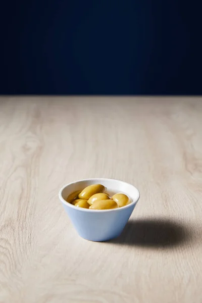 Olive fresche in ciotola su tavolo di legno isolato su nero — Foto stock