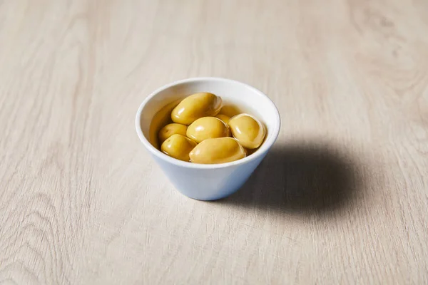 Fresh olives in bowl on wooden table — Stock Photo