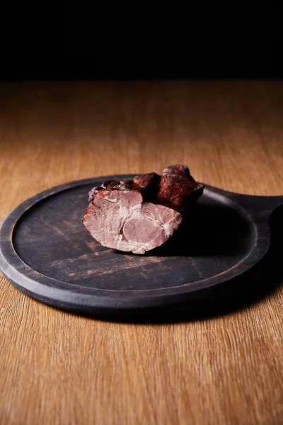 Tasty baked homemade ham on board on wooden table — Stock Photo