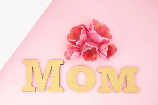 Top view of tulips and mom lettering on pink and white background — Stock Photo