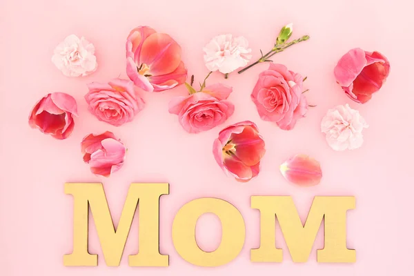 Draufsicht auf blühende Frühlingsblumen und Mama-Schriftzug auf rosa Hintergrund — Stockfoto