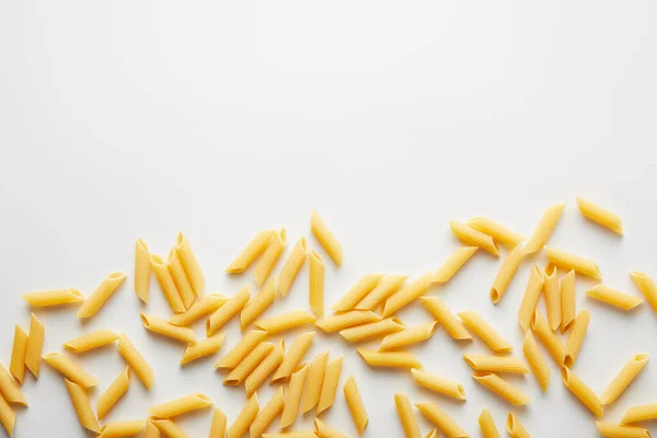 Draufsicht auf ungekochte Pasta auf weißem Hintergrund — Stockfoto
