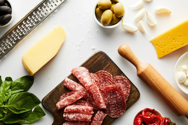 Top view of grater, meat platter, rolling pin and ingredients on white background — Stock Photo