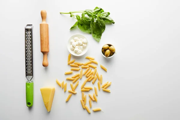 Pose plate avec rouleau à pâtisserie, râpe et ingrédients sur blanc — Photo de stock