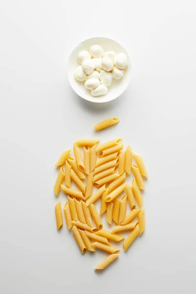 Top view of pasta and bowl with mozzarella on white background — Stock Photo