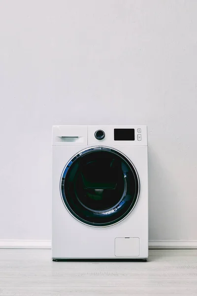 Lavadora cerca de la pared blanca en el baño - foto de stock