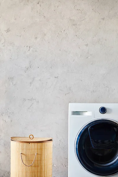 Panier à linge près de la machine à laver blanche dans la salle de bain moderne — Photo de stock