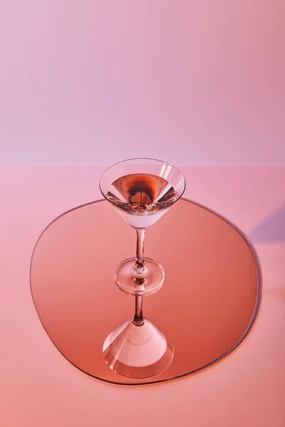 Cocktailglas mit Flüssigkeit auf Spiegel mit Reflexion — Stockfoto