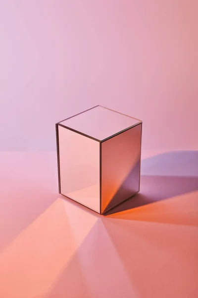 Cubo con riflesso di luce sulla superficie su sfondo viola e rosa — Foto stock