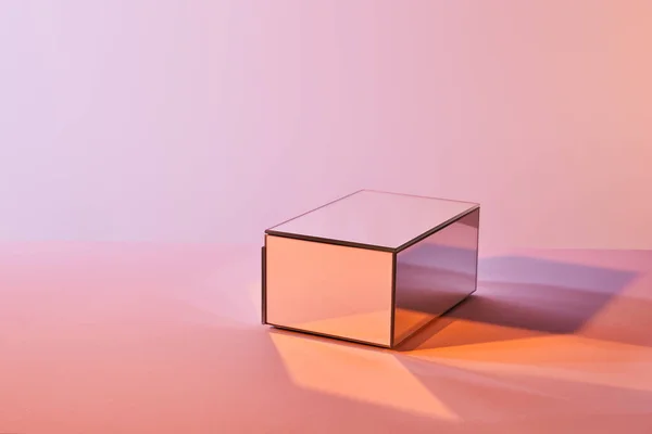 Cube avec réflexion lumineuse sur la surface sur fond violet et rose — Photo de stock